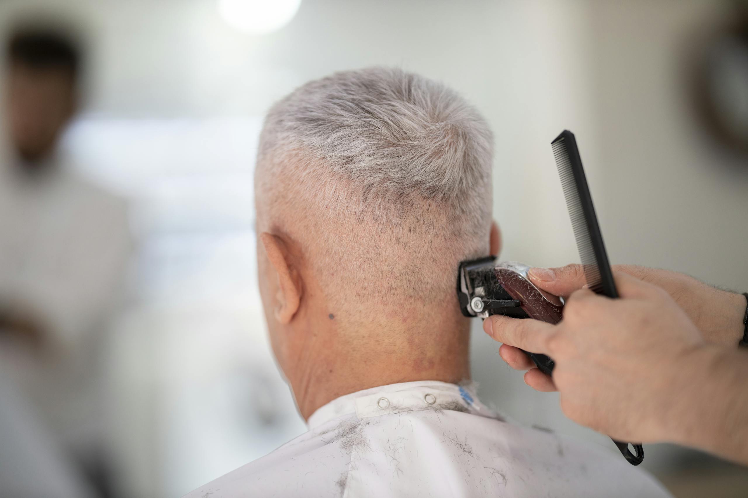 Person Using Hair Razor on Man's Hair